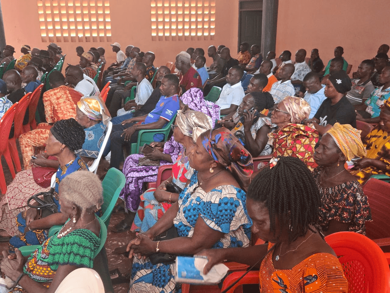 Rangées de participants attentifs assis dans la salle de réunion.