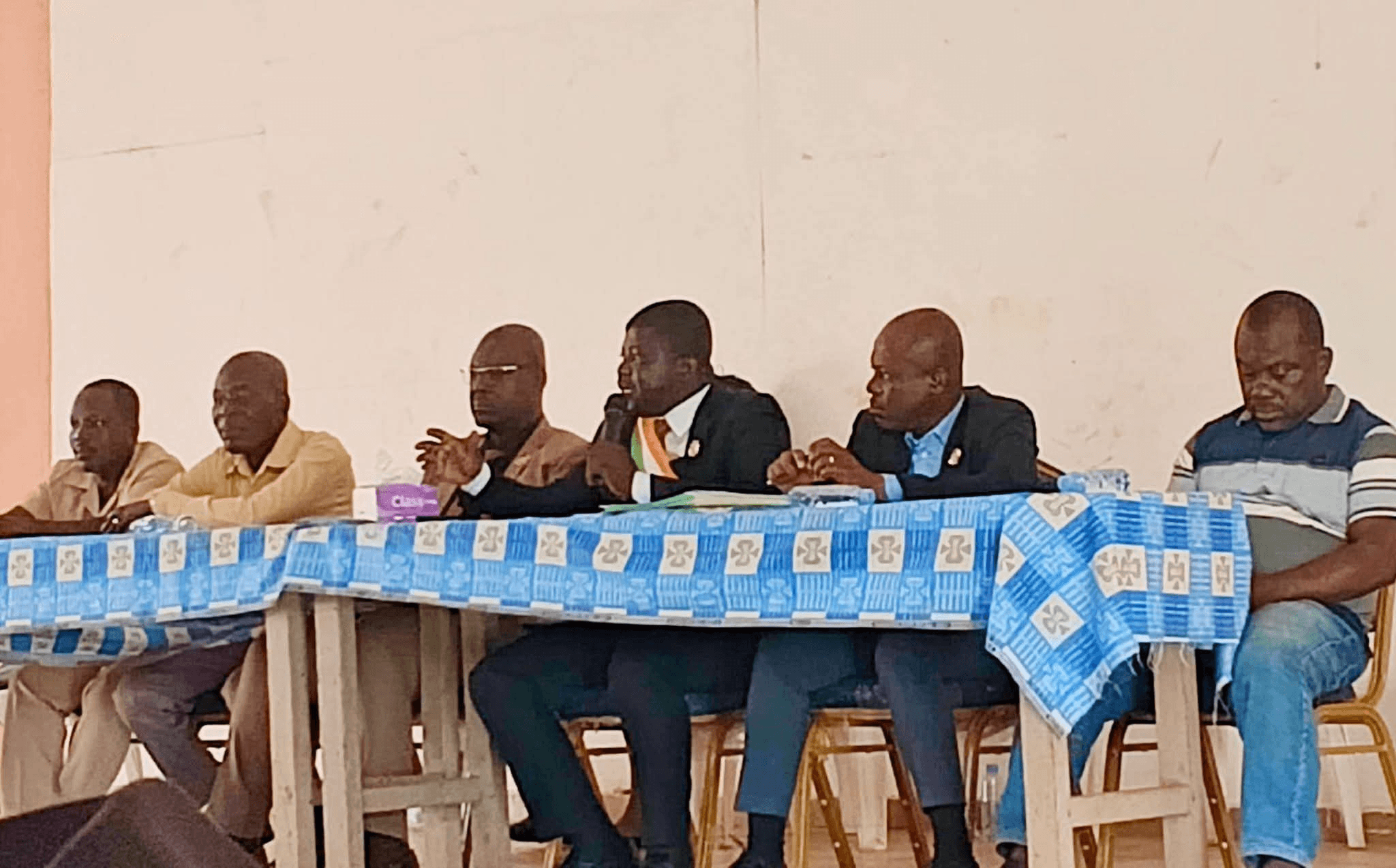 L'Honorable Innocent Yao s'exprimant au micro à la table d'honneur avec d'autres personnalités.