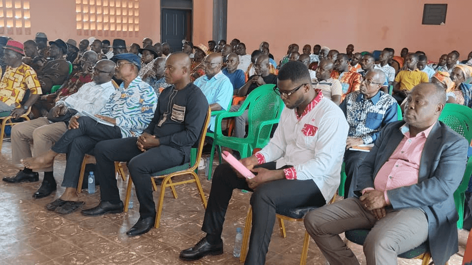 Personnes assises au premier rang consultant des documents lors de la réunion.