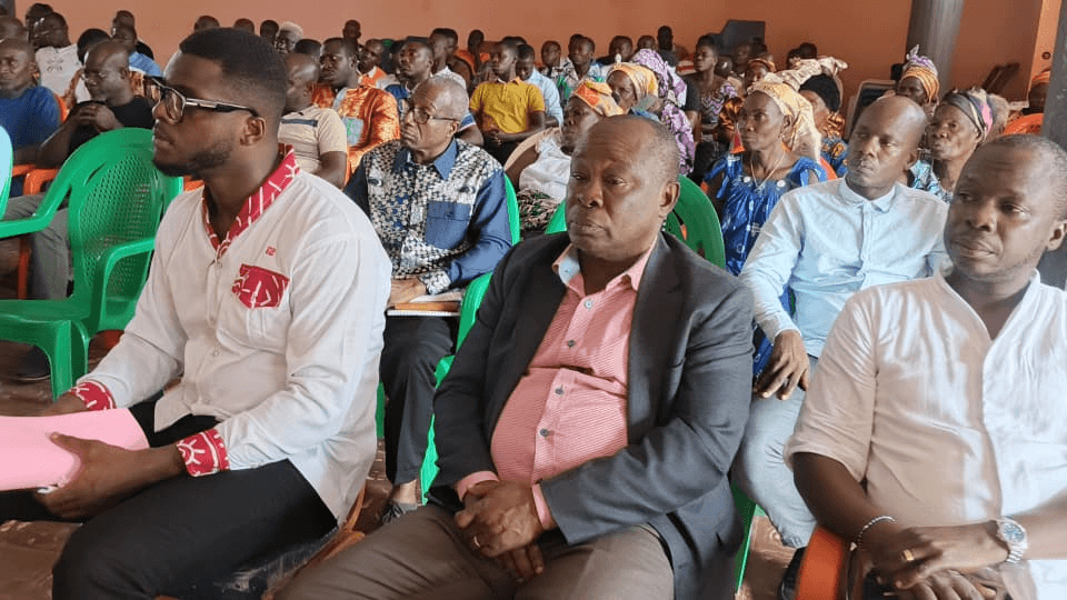 Participants attentifs assis dans la salle de conférence.
