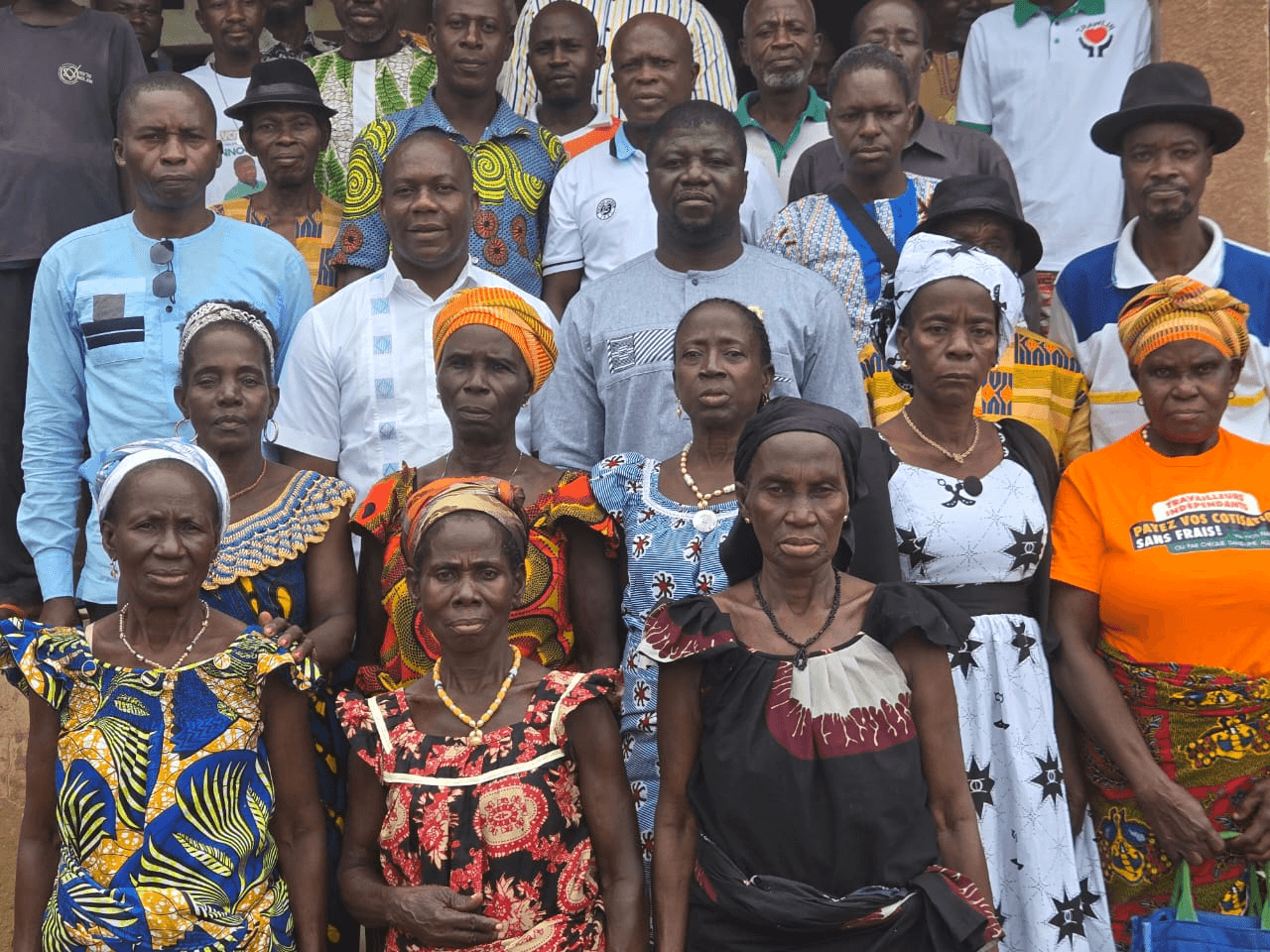 L'Honorable Innocent Yao entouré de nombreuses femmes et hommes de la communauté en tenues traditionnelles.